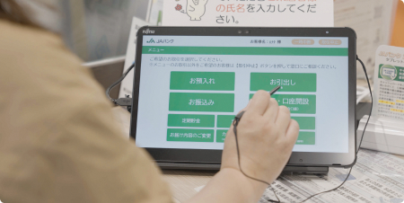 モニターをタッチペンでさわっている